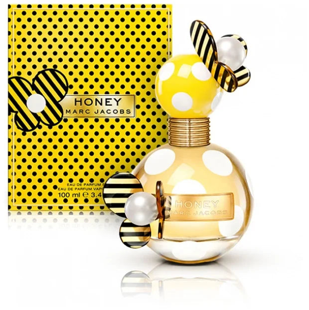 HONEY 3.3 OZ EDP by Paris Connection Perfumes features a stunning honey-colored glass bottle, elegantly shaped like a droplet, and beautifully packaged in a vibrant yellow box adorned with floral accents.