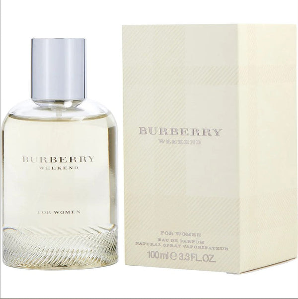 BURBERRY WEEKEND 3.3 OZ EDP W bottle with a serene outdoor setting.