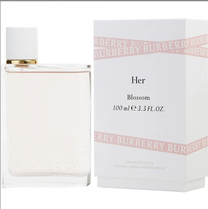 BURBERRY HER BLOSSOM 3.3 OZ EDT bottle surrounded by flowers, from Paris Connection Perfumes.