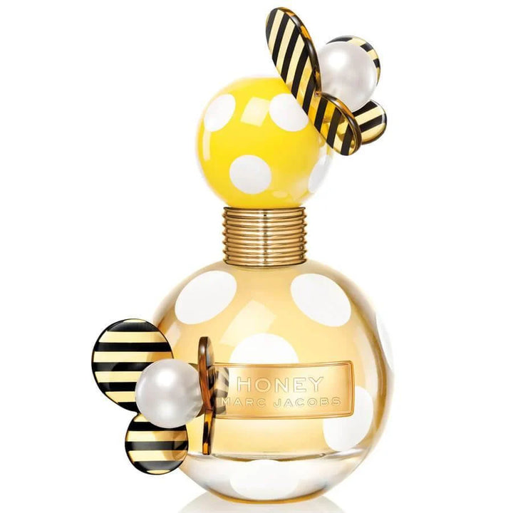 HONEY 3.3 OZ EDP from Paris Connection Perfumes is presented in a chic, golden-hued bottle that resembles a honeycomb, housed in a sleek, modern packaging with artistic designs that reflect its sweet fragrance.