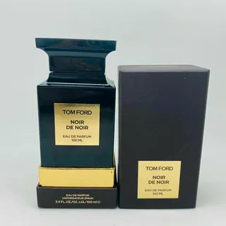 Tom Ford Noir De Noir Eau De Parfum Spray 3.4 oz, elegantly presented in a sleek black glass bottle with a textured finish, showcasing Paris Connection Perfumes' luxurious offerings. The sophisticated packaging features gold accents, reflecting the opulence of the fragrance within.