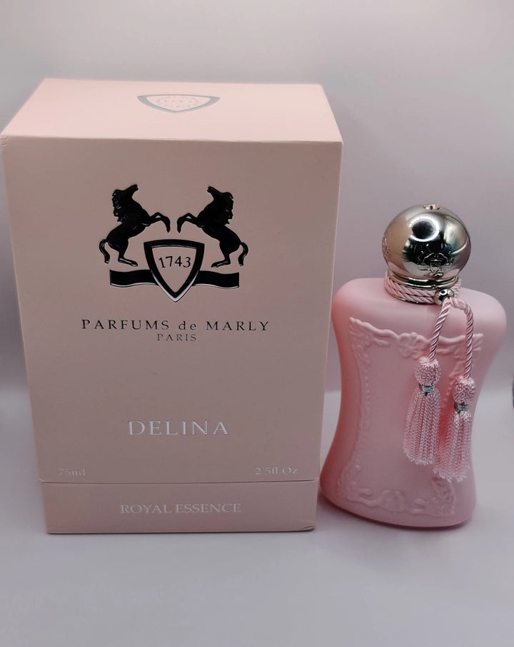 Experience DELINA EXCLUSIF 2.5 OZ PARFUM from Paris Connection Perfumes, featuring an exquisite bottle with soft curves and a delicate pink hue, complemented by sophisticated packaging that reflects the fragrance's opulent character.